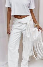 White satin fringe scarf belt tied around the waist with a prominent knot and long flowing fringe