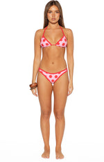 Front view of pink bikini bottoms with red polka dots and red contrast binding, cheeky cut