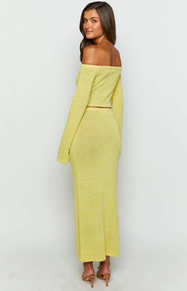 Rear-side view of the yellow knit maxi skirt, showing its fitted silhouette, textured fabric, and maxi length