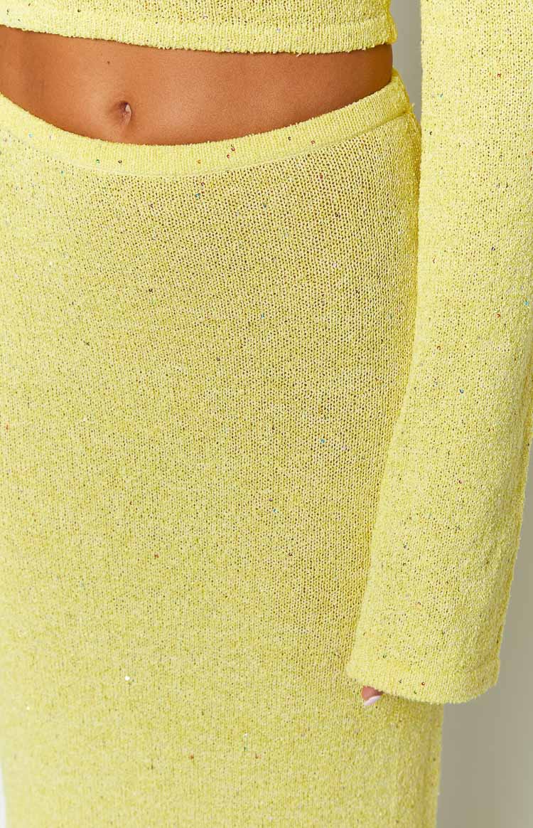 Close-up of the yellow knit maxi skirt's waistband and textured fabric with subtle sparkle