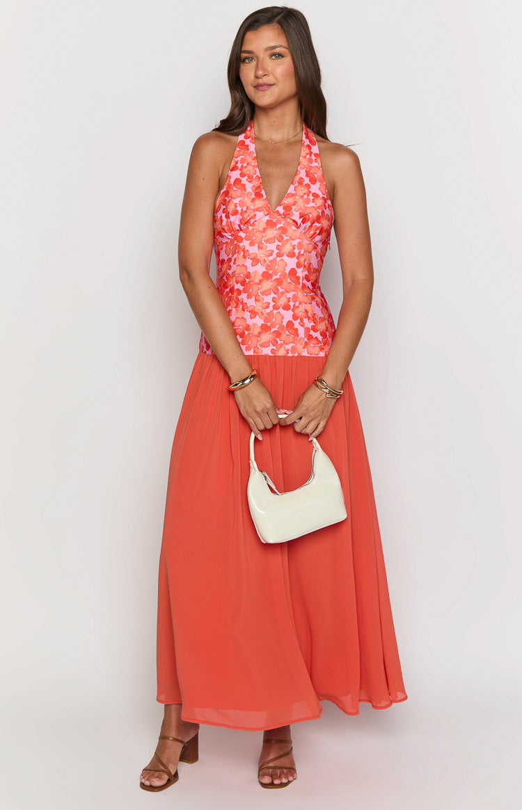 Front view of an orange floral maxi dress with a pink and orange floral halter V-neck bodice and a flowing orange skirt