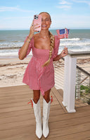 Close-up of the square neckline and puffed sleeves of a red gingham babydoll mini dress