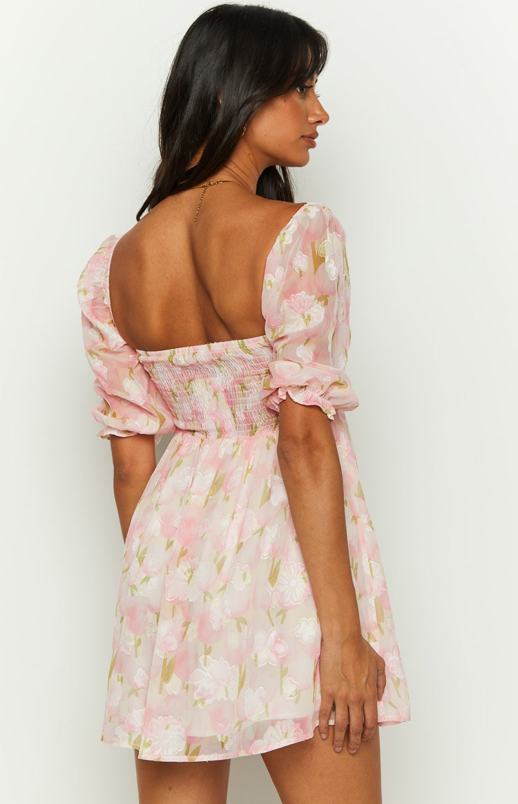 Rear view of a pink floral babydoll mini dress with a square back neckline and shirred bodice