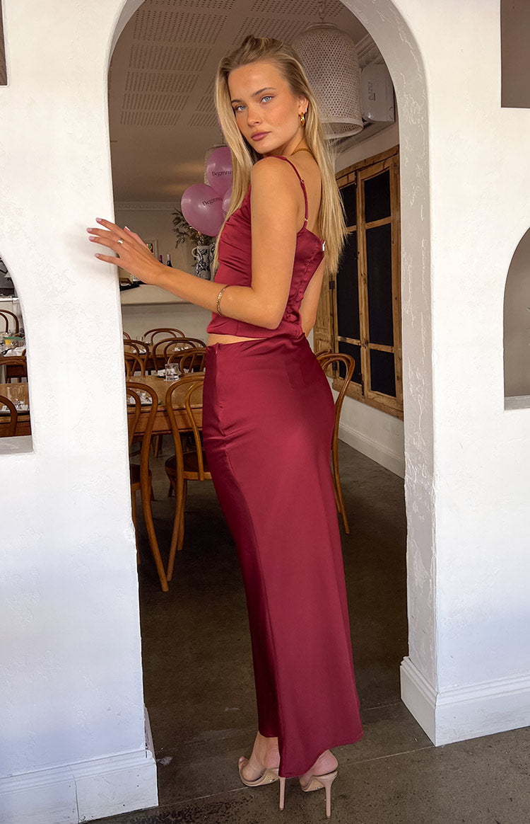 Girl wearing red satin maxi skirt and top with nude high heels.