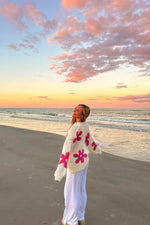 Side and back view of a cream knit sweater with large pink flower patterns and long sleeves