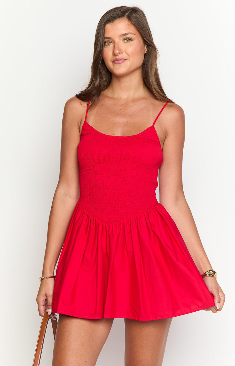 Red mini dress with a shirred bodice, thin spaghetti straps, V-shaped empire waist, and gathered A-line skirt