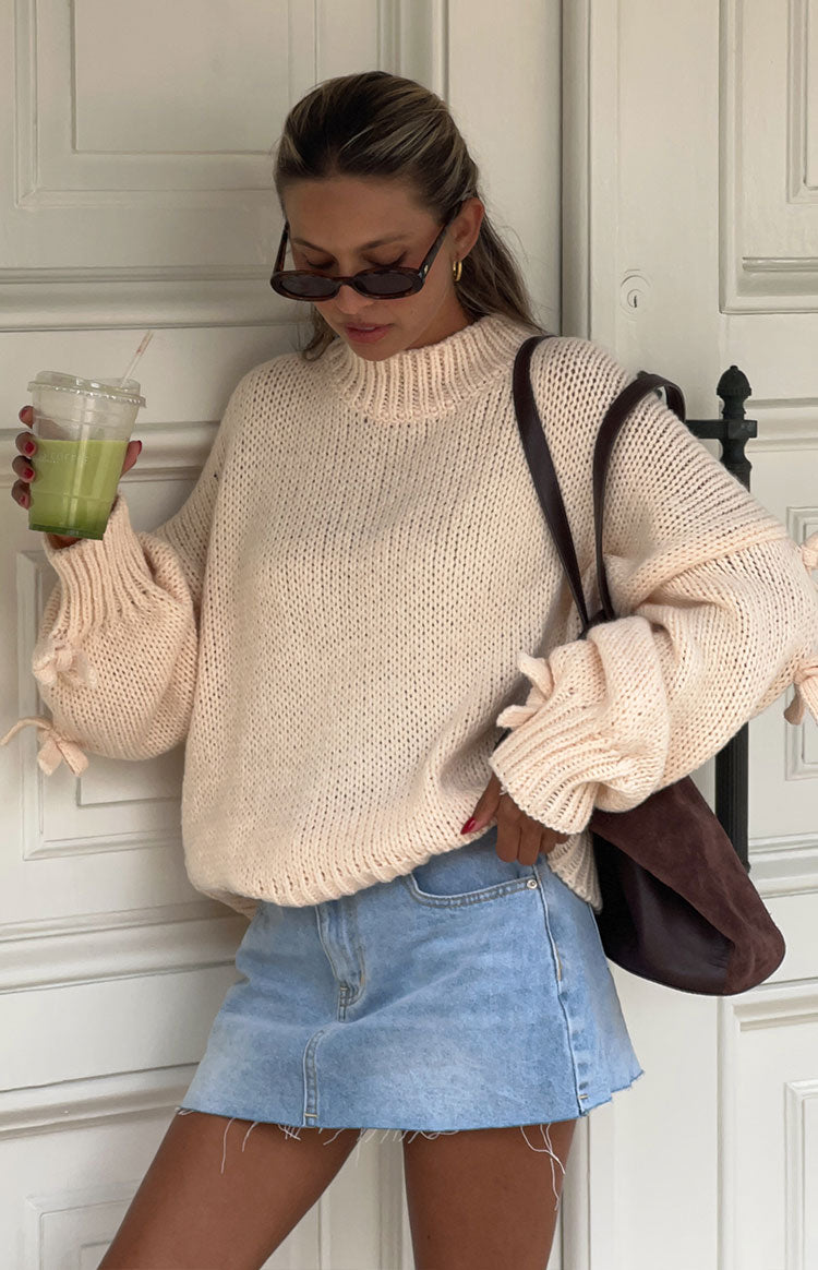 Cream chunky knit jumper with a high mock neck and voluminous balloon sleeves with tie cuffs