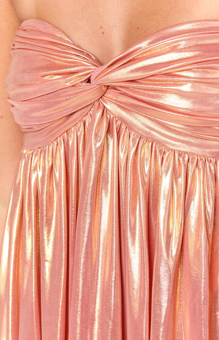 Detail shot of the twisted bust and gathered waist of an orange metallic strapless mini dress