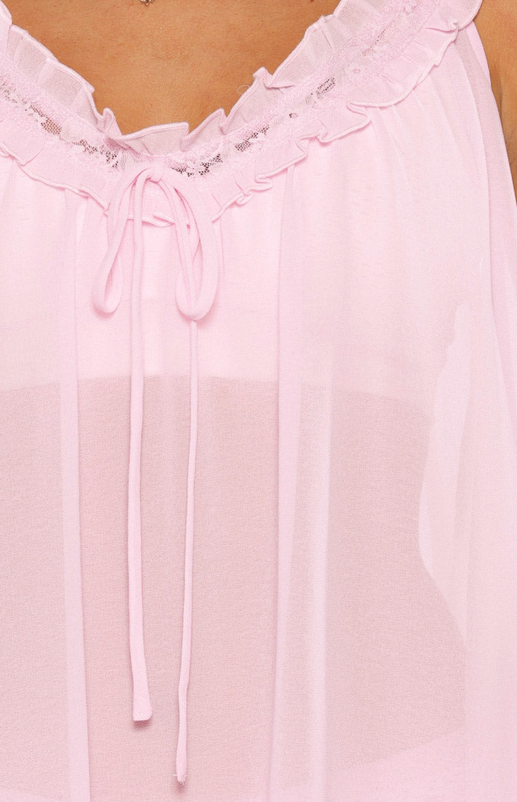 Close-up of the pink sheer mini dress showing the frilled neckline with lace trim and a tie-front detail