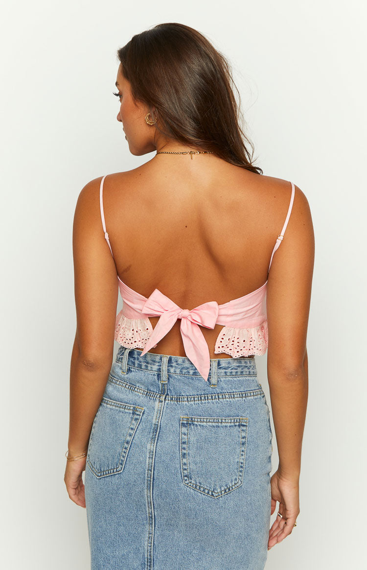 Rear view of a pink crop top with a large bow tie back and eyelet lace trim