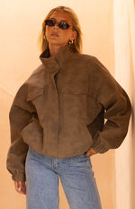 Brown oversized suedette jacket featuring a high funnel neck and two flap chest pockets