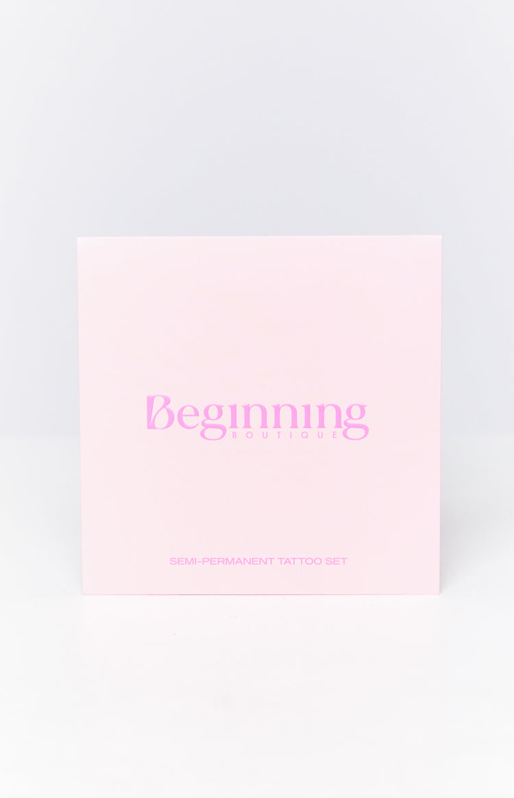 Front view of a light pink box featuring a pink script Beginning Boutique logo and SEMI-PERMANENT TATTOO SET text