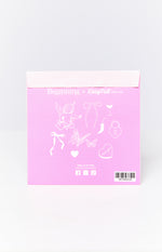 Pink envelope with white line art illustrations of a cherub, bows, butterflies, heart with 'love you', padlock, chili, and cocktail glass