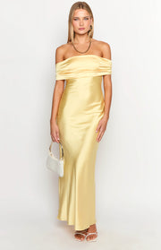 Front view of a yellow satin off-the-shoulder maxi dress with a draped neckline and fitted silhouette