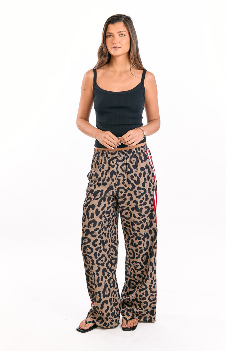 Full-length view of leopard print wide-leg pants with an elasticated waist and red and white racer stripes