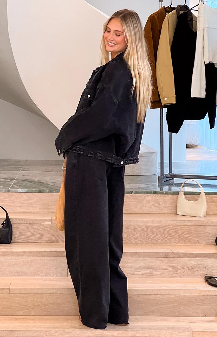 Side view of black wide-leg boyfriend jeans with a relaxed fit and full-length drape