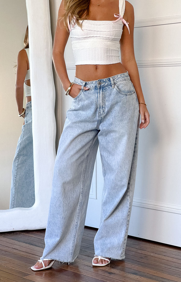 Front view of light wash wide leg boyfriend jeans with a raw edge hem