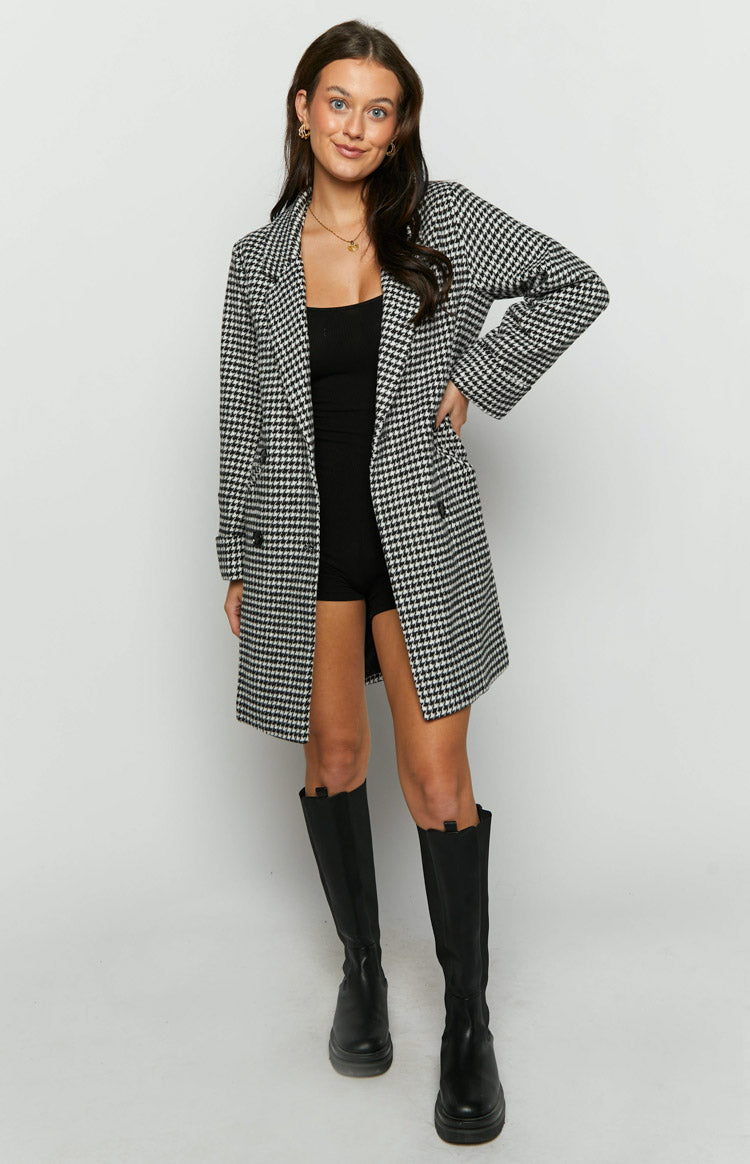 Black and white check longline jacket with double-breasted front, side pockets, and rolled cuffs