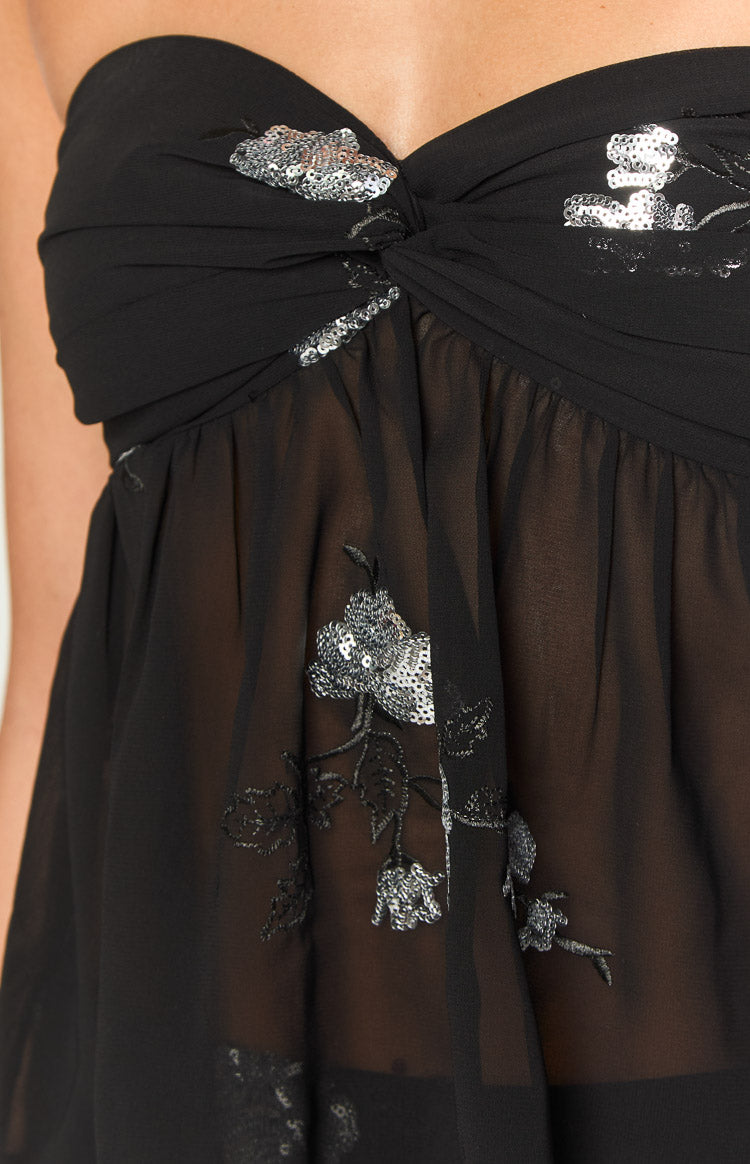 Close-up of the black sheer strapless top with twisted bust detail and silver sequin floral embroidery