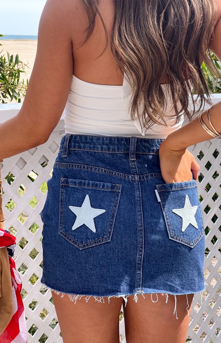 Beginning Boutique Siletto Star Blue Denim Low Rise Mini Skirt with light blue star patches on back pockets and frayed hem