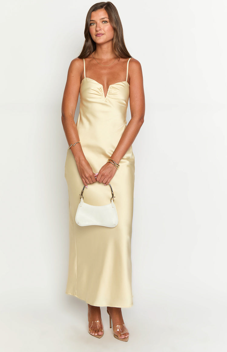 Front view of a pale yellow satin maxi dress with spaghetti straps and a gathered V-neckline