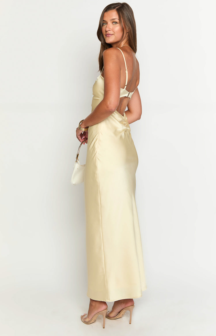 Side view of a yellow satin maxi dress showing the open back with thin spaghetti straps and a horizontal strap