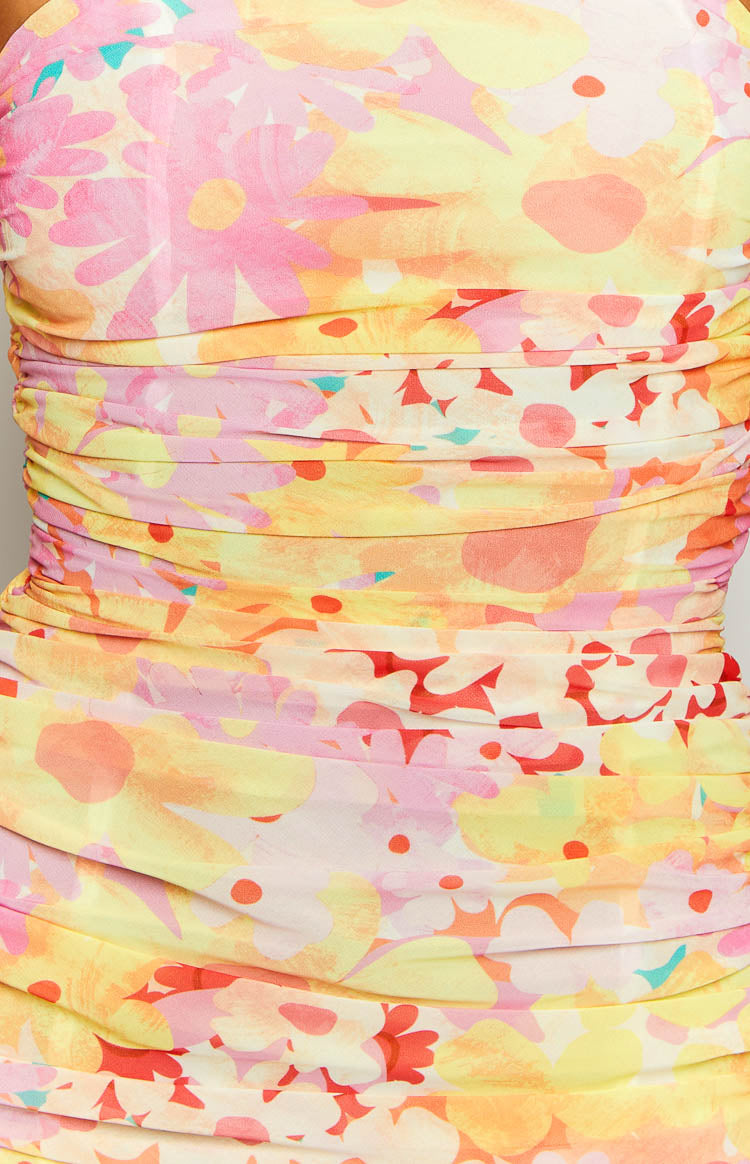 Close-up of the ruched detail on a yellow floral print strapless maxi dress with pink, orange, and red flowers