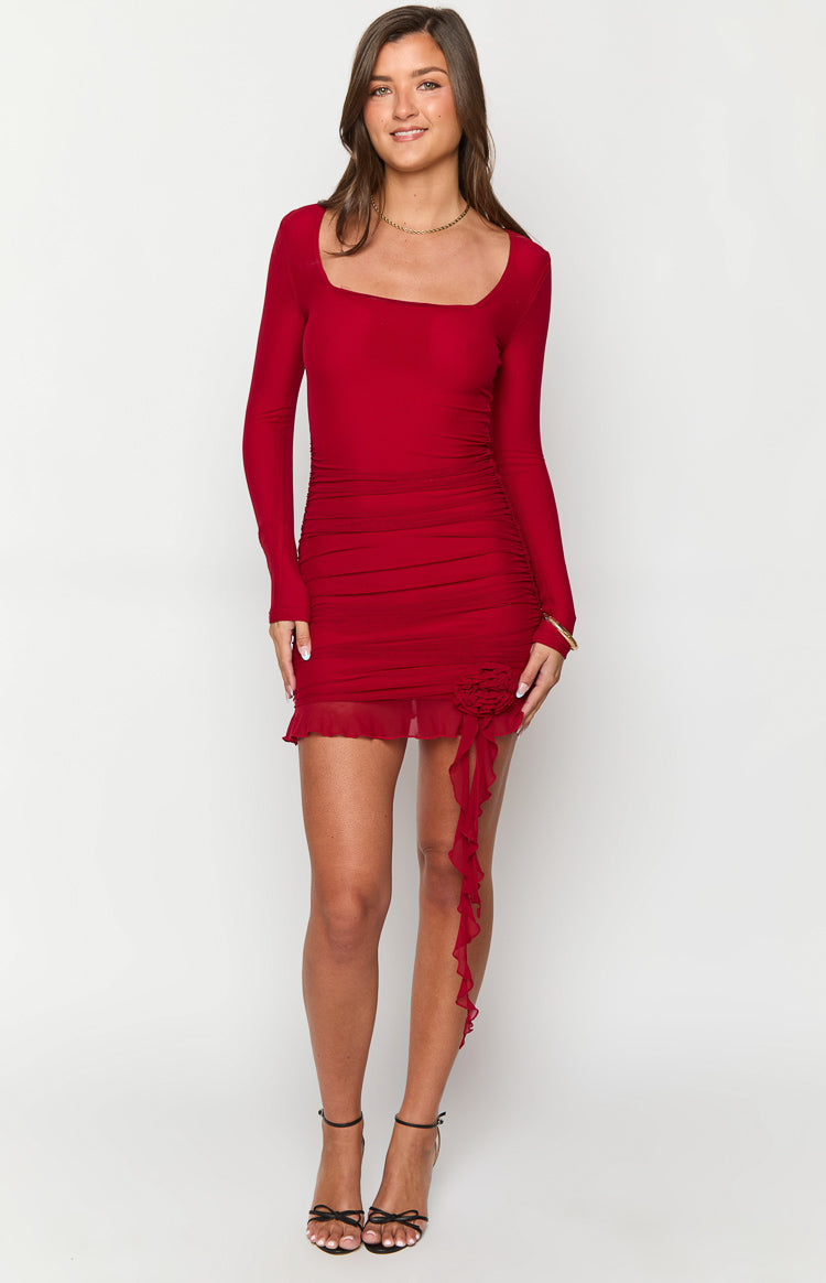 Red long sleeve mini dress with square neckline, ruched body, sheer ruffled hem, and floral appliqué with ties