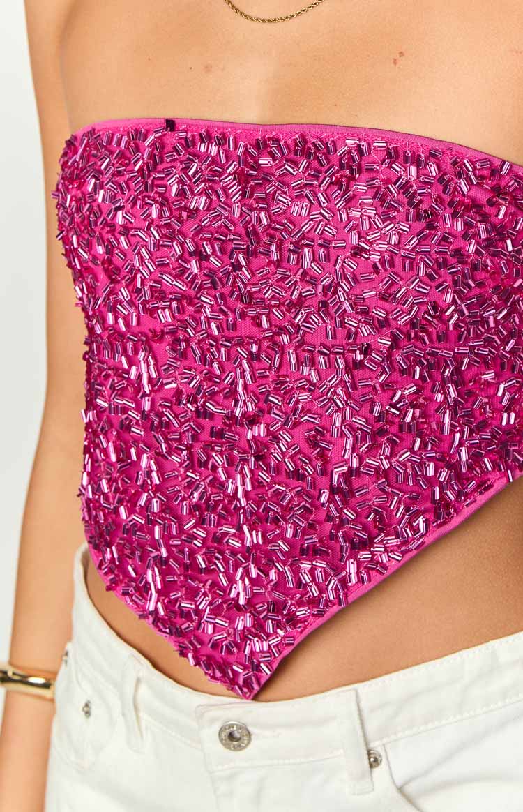 Close-up of the fuchsia pink strapless top's pointed hem and the texture of the individual bead sequins
