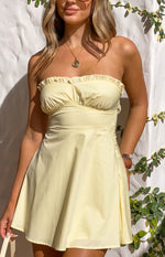 Close-up of a yellow strapless mini dress with a ruffled neckline and gathered bodice