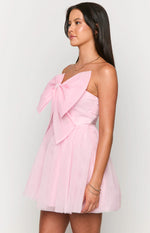 Side view of a pink strapless mini dress with a large bow on the bust and a full, layered tulle skirt, showing the side zipper