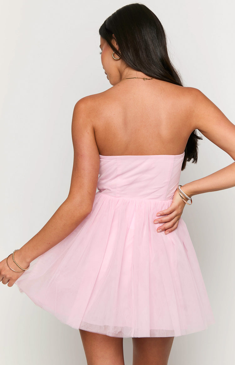 Back view of a pink strapless mini dress with a fitted bodice and a voluminous layered tulle skirt