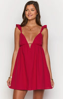Girl wearing red mini dress and beige heels holding cocktail wine glass.