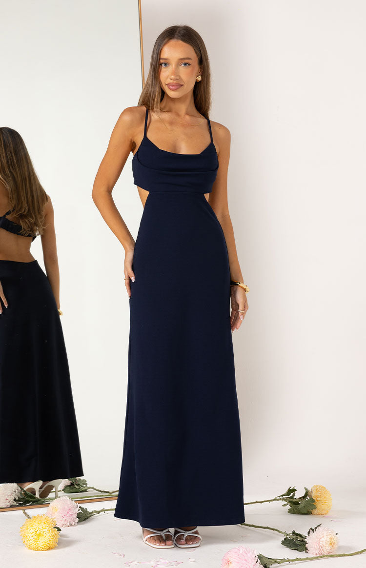 Front view of a navy crepe maxi dress with a cowl neck, thin straps, and side waist cutouts