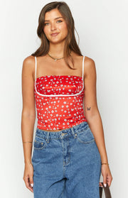 Red floral crop top featuring a square neckline, thin white spaghetti straps, and white underbust piping