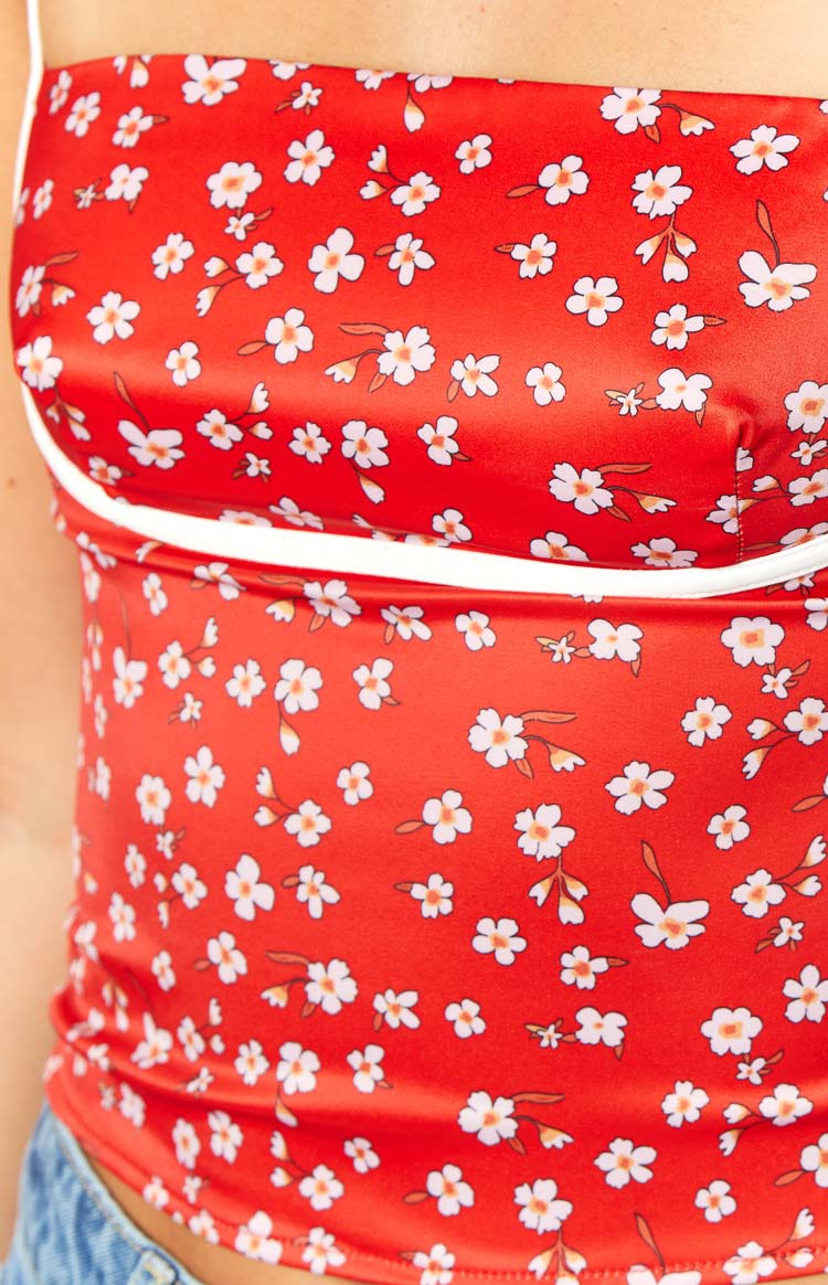 Close-up of the red floral fabric with white piping detail on the bust of the top