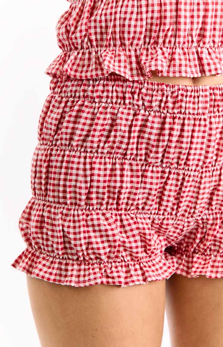 Close-up of red and white gingham shorts with shirred elasticated fabric and ruffled leg openings
