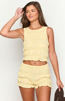 model wearing a yellow gingham sleeveless top with ruched and ruffle details 
