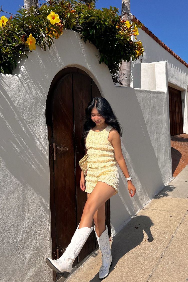 Profile view of bright yellow textured shorts with a high-rise waist and short hem