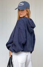 Rear-side view of a washed navy oversized hooded jacket with dropped shoulders and voluminous sleeves