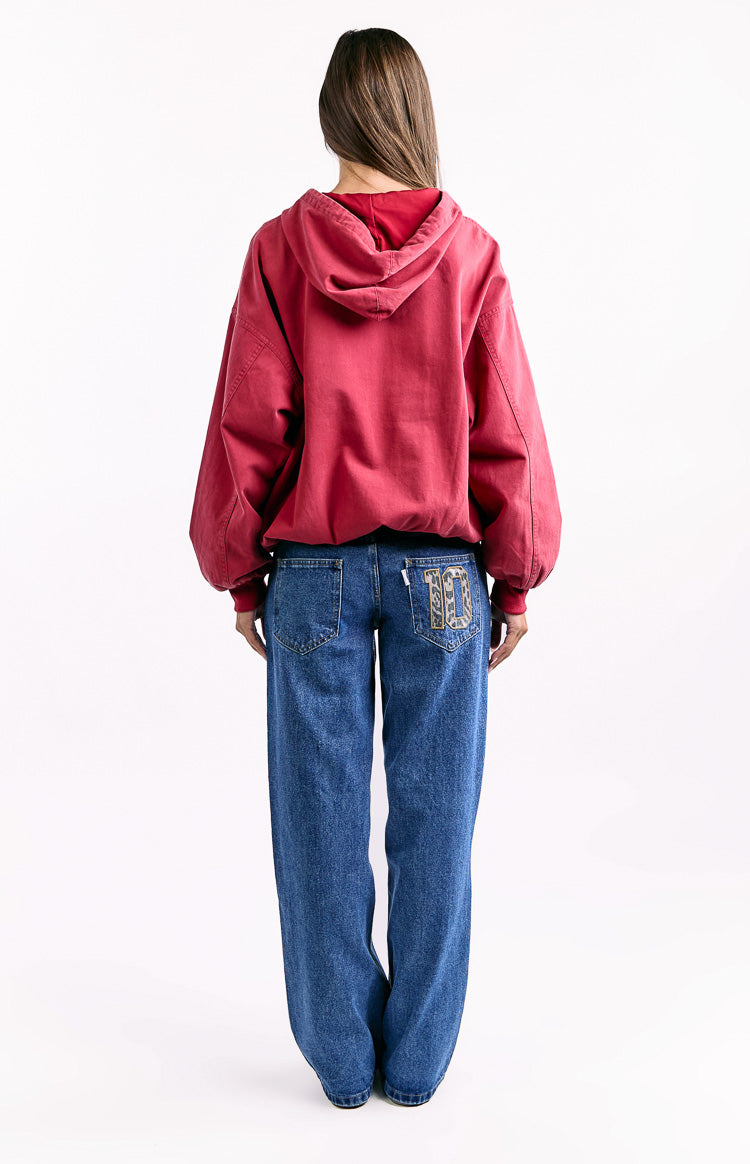 Rear view of a washed red oversized hooded jacket with voluminous sleeves and a cinched hem