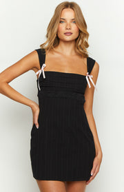 Black pinstripe mini dress with square neckline, pintuck bodice, black lace trim, and pink ribbon bows on the shoulder straps