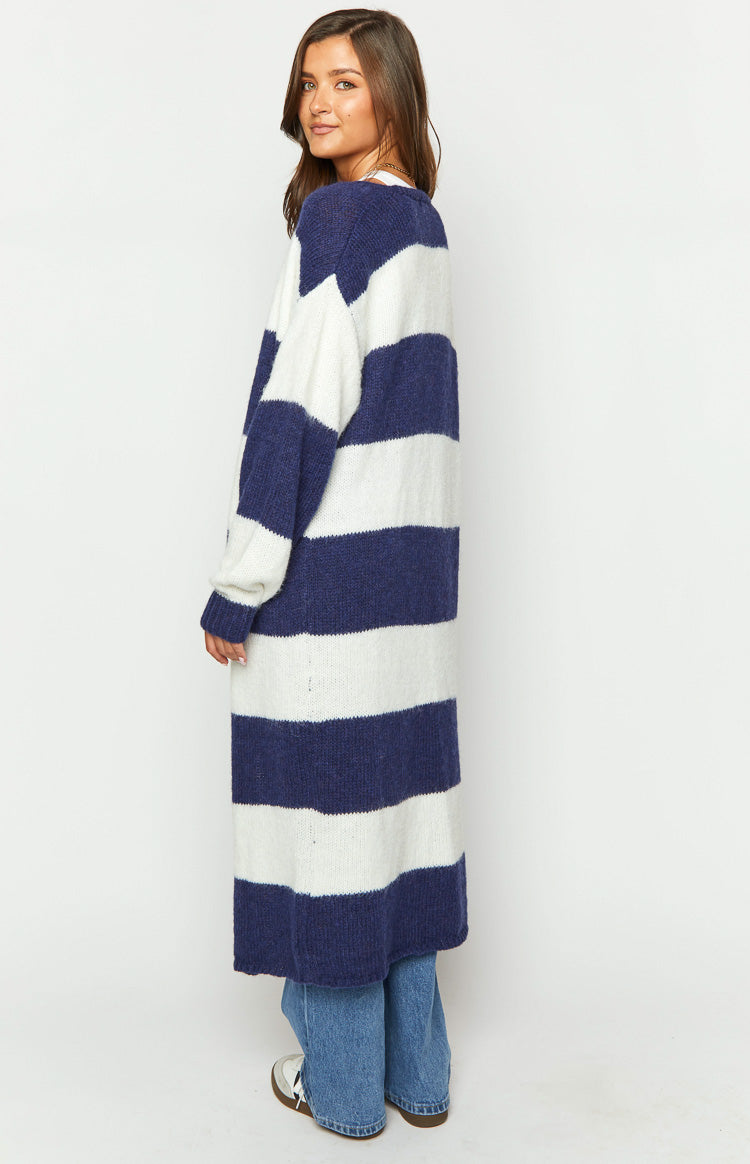 Side view of a longline blue and white striped knit cardigan with wide horizontal stripes and a fuzzy texture