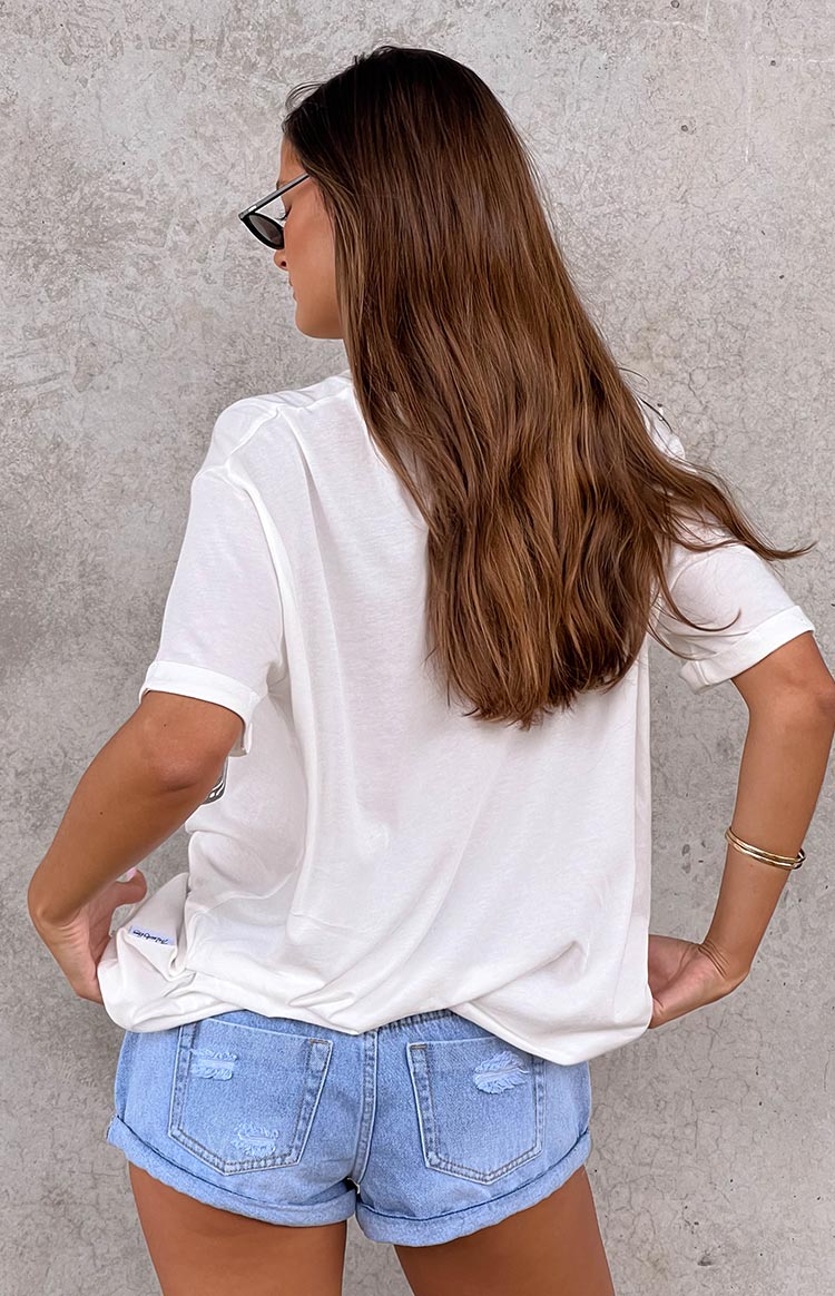 Rear view of a white oversized tee with cuffed short sleeves and a relaxed fit