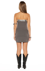 Rear view of a grey strapless mini dress with a silver sequin trim along the top