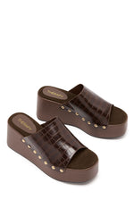 Angled view of two chocolate brown croc-embossed PU wedge sandals with gold stud details and dark brown footbeds