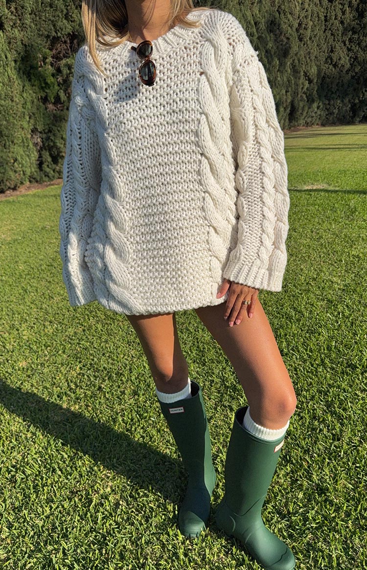 Oversized cream cable knit sweater dress with a chunky texture and short length