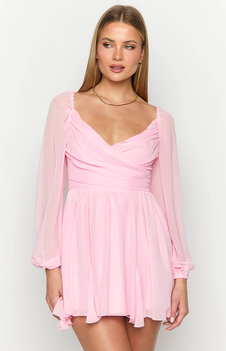 Pink mini dress with a sweetheart neckline, ruched bust, and sheer long sleeves