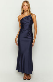 Front view of a navy one-shoulder maxi dress with a draped and ruched bodice and a smooth flowing maxi skirt