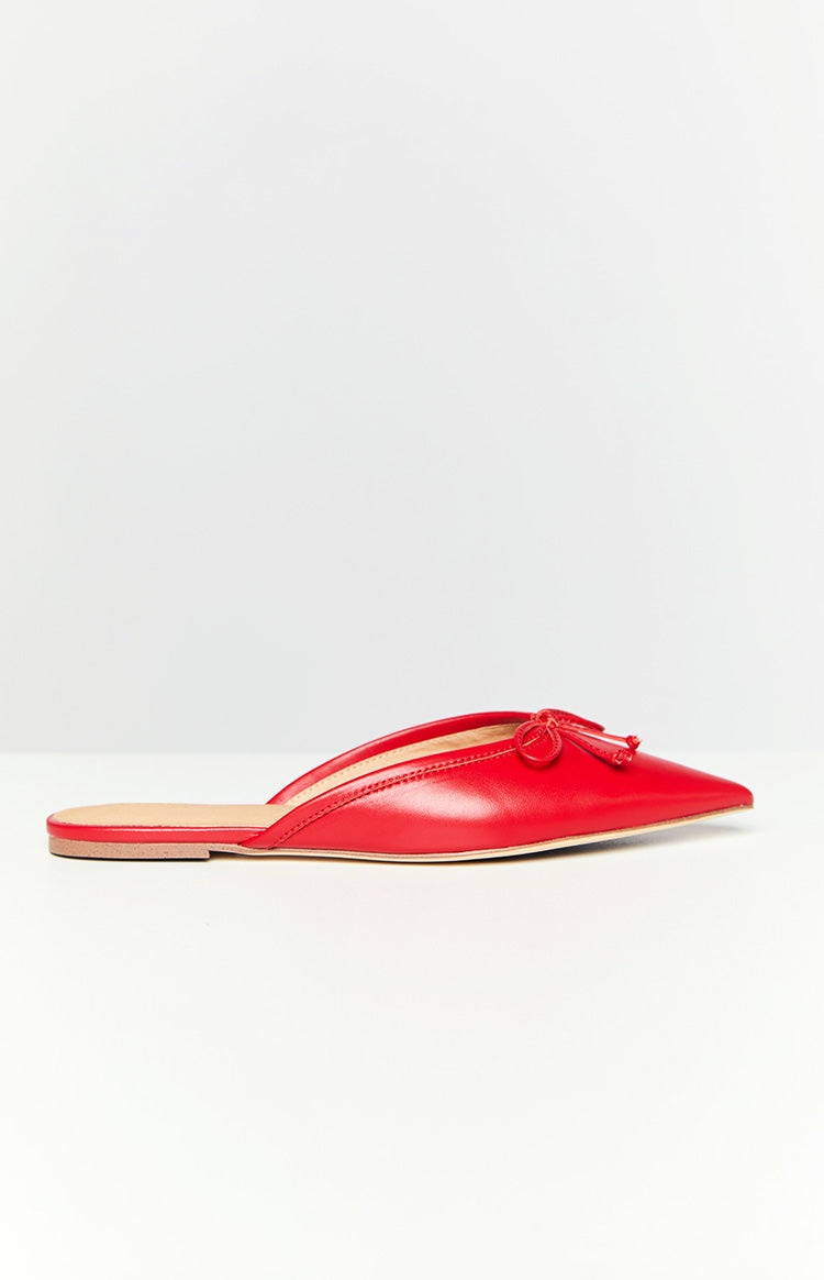 Side view of a ruby red pointed toe mule flat with a small bow detail on the front